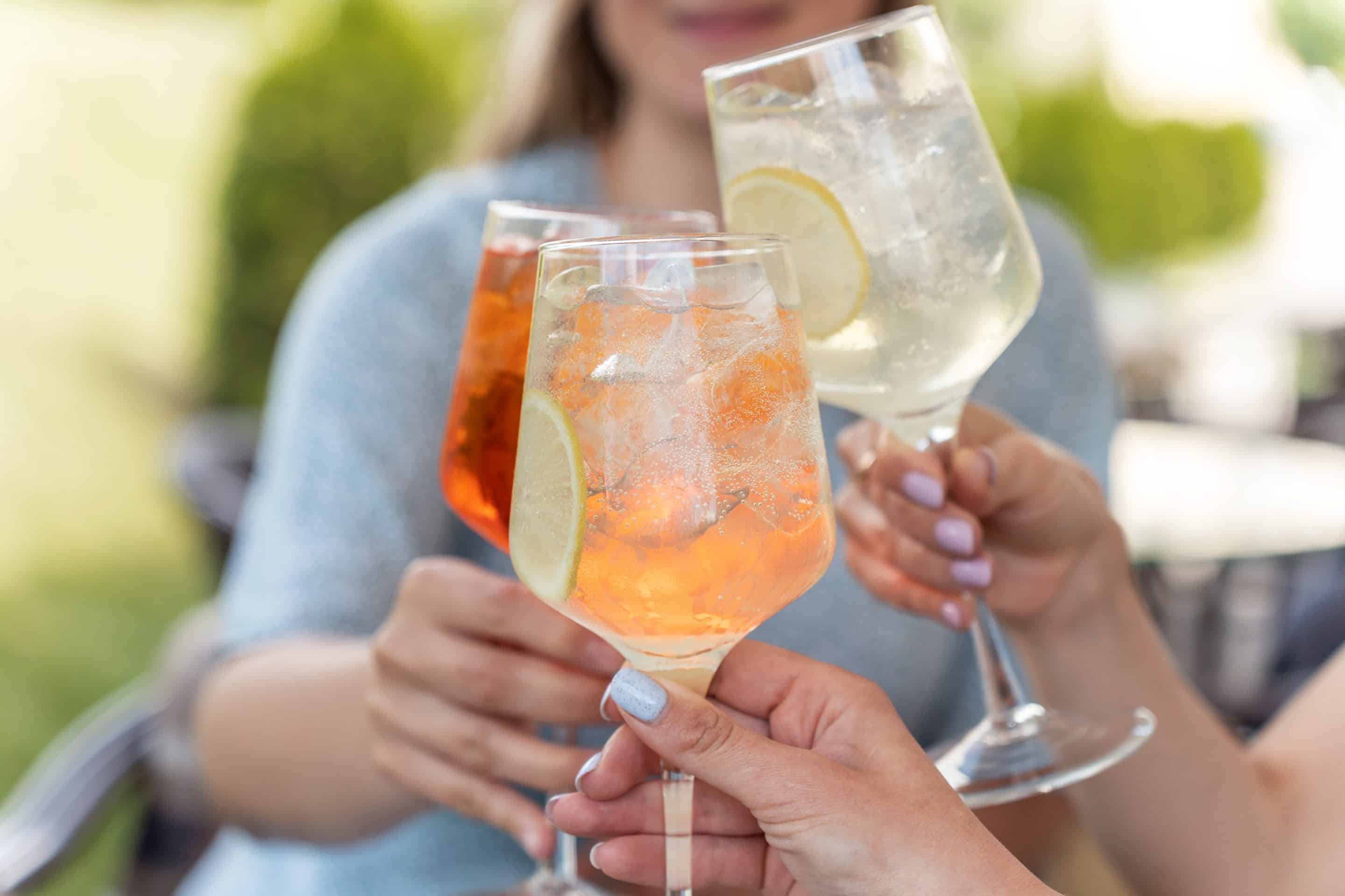 Woman,hands,toasting,with,aperol,spritz,cocktails